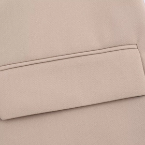 Detailed macro view of beige blazer pocket flap and fine twill fabric texture