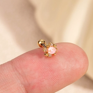 Clou de cartilage fleur dorée avec zircon rose et fermoir à bille sur le doigt