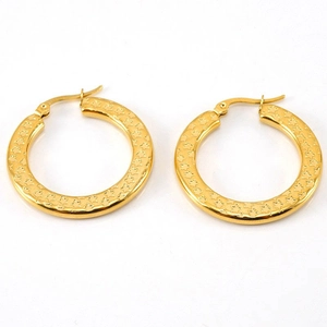 Golden oversized hoop earrings with retro etched star texture on white background