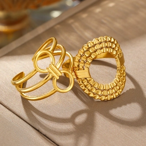 Detail of gold minimalist hollow bow and layered wave textured open rings for women