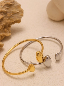 Mise en scène artistique de deux joncs ouverts en forme de cœur or 18 carats et argent