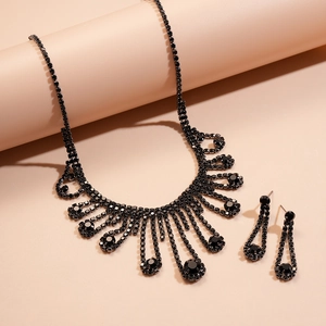 Detailed view of luxury black rhinestone necklace and matching earrings set on warm background