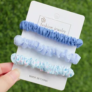 Détail de chouchous en tissu bleu sur carte de présentation avec fond d'herbe naturelle