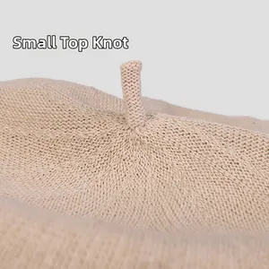 Gros plan sur le petit détail supérieur et la texture tricotée fine d'un bonnet beige