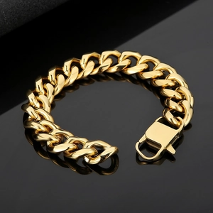 Polished gold curb chain bracelet with strong lobster clasp on reflective black surface