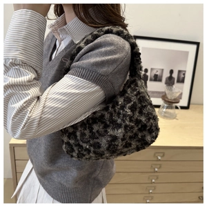 Close-up of leopard print plush handbag showing soft faux fur texture and handle detail