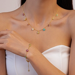 Golden necklace and bracelet set with colorful enamel flower and ladybug charms