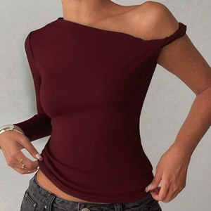 Detail of burgundy one-shoulder top showing the twisted strap and asymmetric neckline