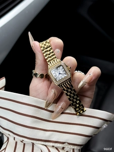 Detail of a gold square quartz watch with diamond bezel and Roman numeral white dial