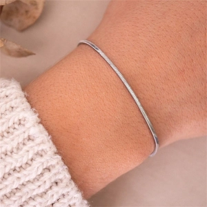 Close-up of minimalist silver snake bone chain bracelet worn on a female wrist