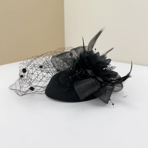 Detail of a vintage black fascinator with mesh flower, feathers, and polka dot veil