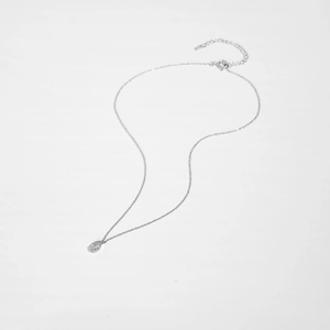 Macro detail of S925 sterling silver chain with a pear-shaped white zircon pendant