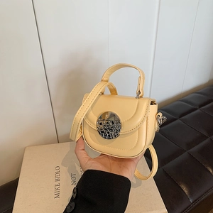 Close-up of yellow mini PU leather crossbody bag with silver round metal buckle detail