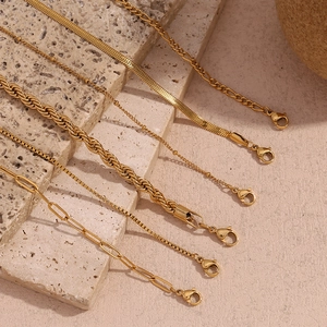 Close-up of 18K gold plated Figaro and snake chain textures with lobster clasp detail