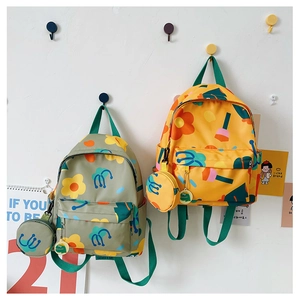 Close-up of children's backpacks in green and yellow with matching mini coin purses