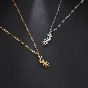 Detailed view of hollowed-out floral pendants in gold and silver stainless steel