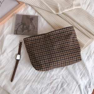 Macro view of vintage brown checkered fabric pouch texture on an elegant white background