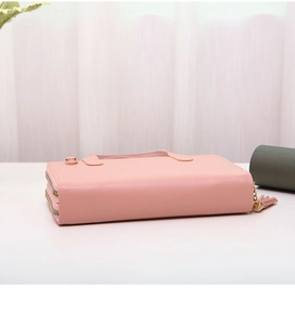 Detail view of pink crossbody cell phone purse with double zippers and tassel charm