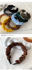 Macro detail of pleated velvet headbands in various colors on a soft carpet texture