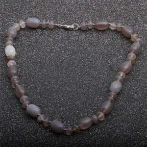 Macro shot of tiger eye and opal beads on a necklace with a metallic lobster clasp