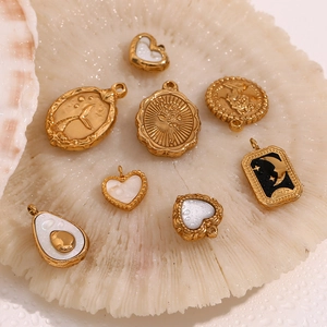 Macro detail of 18K gold plated charms with Lucky engraving on coral decor