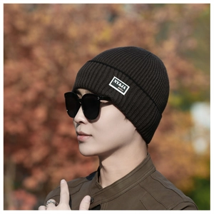 Detailed close-up of dark brown ribbed knit beanie with a stylish side brand label