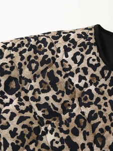 Close-up of leopard print quilted fabric with diamond stitching and black piping trim