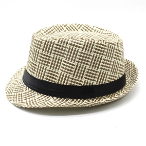 Close-up of beige woven fedora hat with intricate check pattern and black ribbon detail