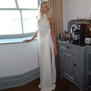 Detail of elegant white high-slit sleeveless dress with draping pleats for evening party