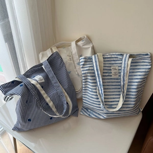 Blue and white striped cotton tote bags with bow embroidery and minimalist woven label