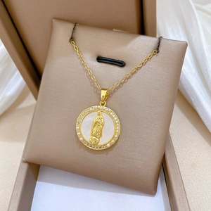 Macro view of gold portrait pendant featuring pearl shell and sparkling rhinestones