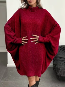Detailed texture of burgundy oversized knit dress with cozy turtleneck and batwing sleeves
