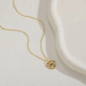 Detailed view of 14K gold plated heart and eye pendant necklace with blue zircon crystal