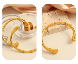 Dettaglio di bracciali aperti in oro e argento con eleganti estremità a goccia