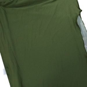 Détail macro du tissu vert foncé montrant l'étiquette d'entretien et la couture