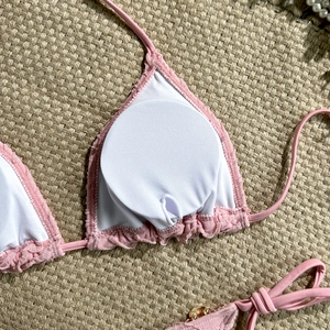 Detail of pink knit bikini top featuring breathable lining, padding and ruffled edges