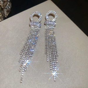 Detailed view of silver tassel earrings with sparkling cubic zirconia and long chain fringes