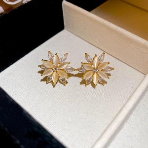 Macro shot of gold floral earrings featuring opal petals and cubic zirconia crystal center