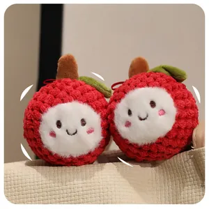 Close-up of red crochet litchi plush toys with embroidered smiley faces and green leaves