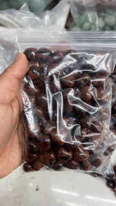 Close-up of 15mm red-brown heart-shaped natural crystal stones in a clear packaging bag