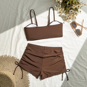Detail of coffee brown two-piece swimsuit with side ruched drawstring on boyleg shorts