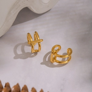Minimalist double layer gold ear cuffs with cross geometric design on textured stone surface