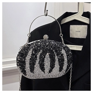 Close-up of sparkling black and silver rhinestone stripes on evening clutch with metal handle