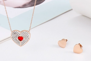 Elegant rose gold jewelry set featuring red heart crystal necklace and matching studs