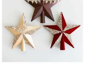 Detailed view of glittering star tree toppers with sequins and beads in brown, beige, and red