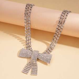 Detailed macro view of triple-layered silver choker necklace with a large crystal bow pendant