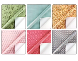 Détail de six rouleaux de papier cadeau aux motifs floraux et géométriques en grille