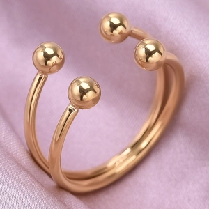 Vue macro d'une bague double anneau en acier inoxydable doré sur soie rose élégante