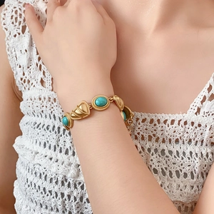 Vue détaillée d'un bracelet doré vintage avec pierres turquoise ovales sur dentelle