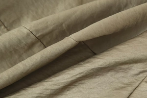 Macro detail of high-quality dark khaki satin fabric with smooth glossy texture
